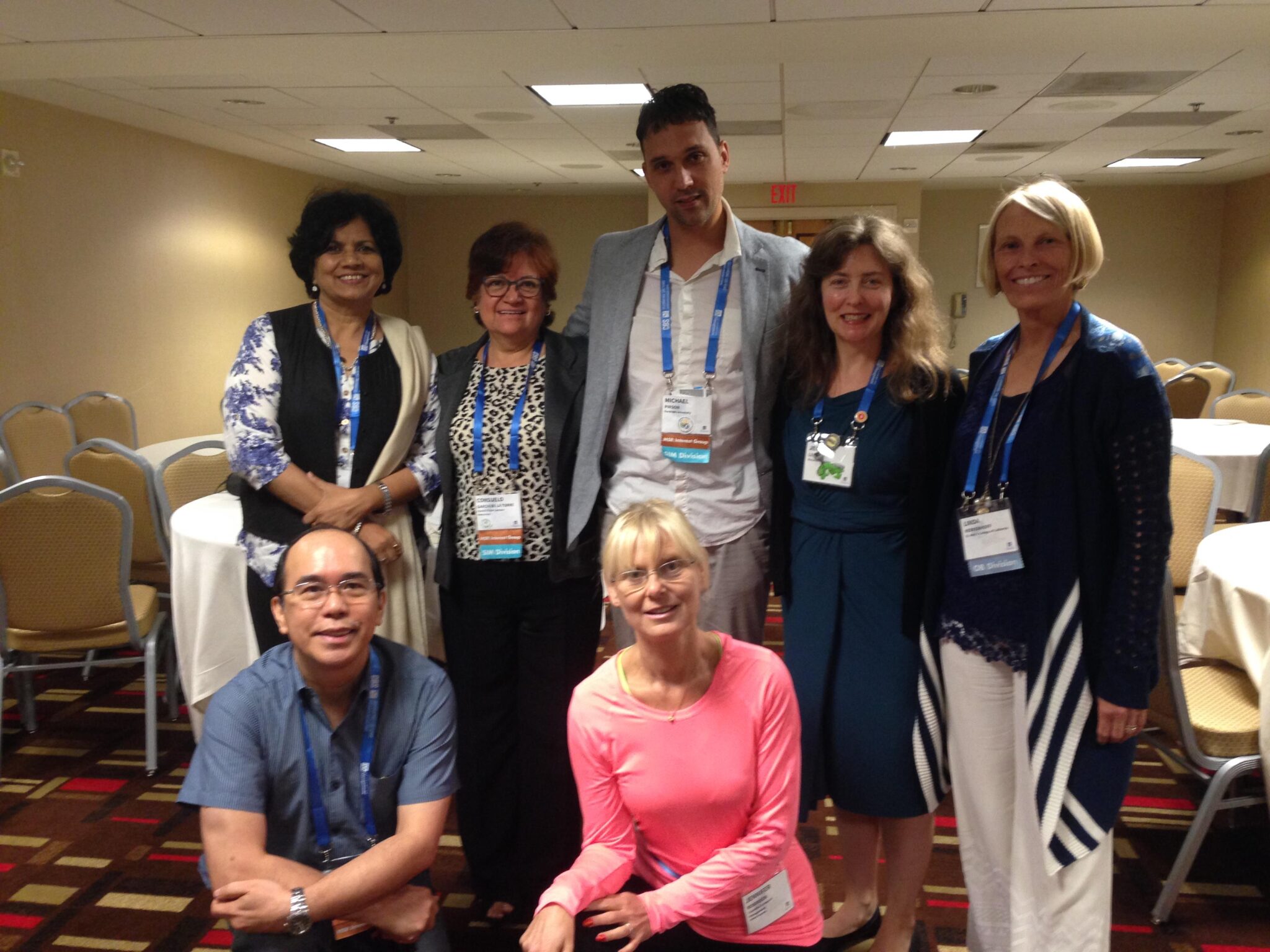 Group of people posing in a conference room.