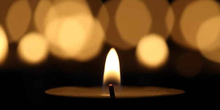 Candle flame with blurred lights background.