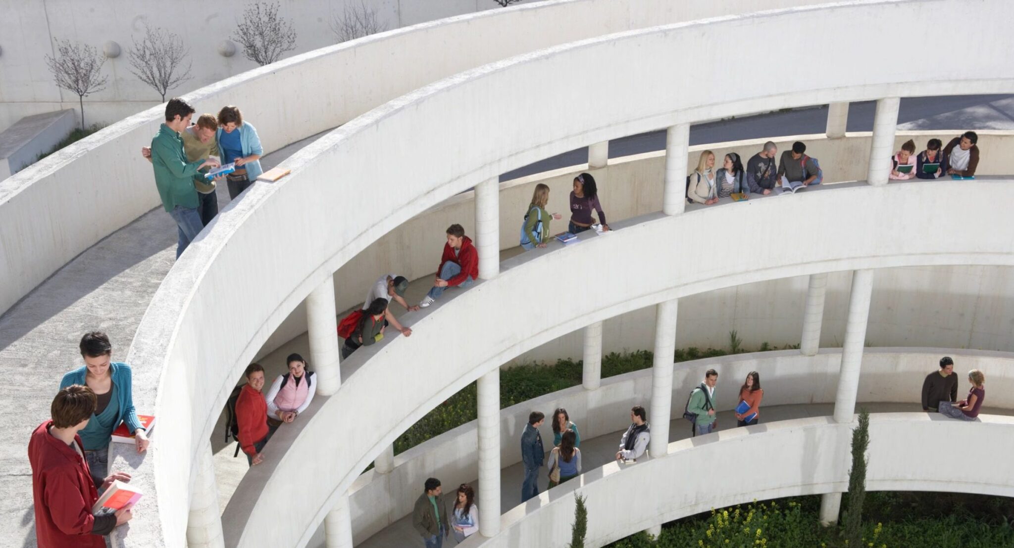 Students on spiral walkway in open-air building.