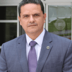 Man in suit standing outside a building.