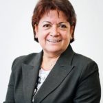 Smiling woman in a dark suit jacket.