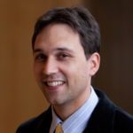 Smiling man in a suit and tie.