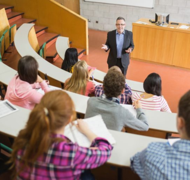 Professor lecturing students in a university classroom.