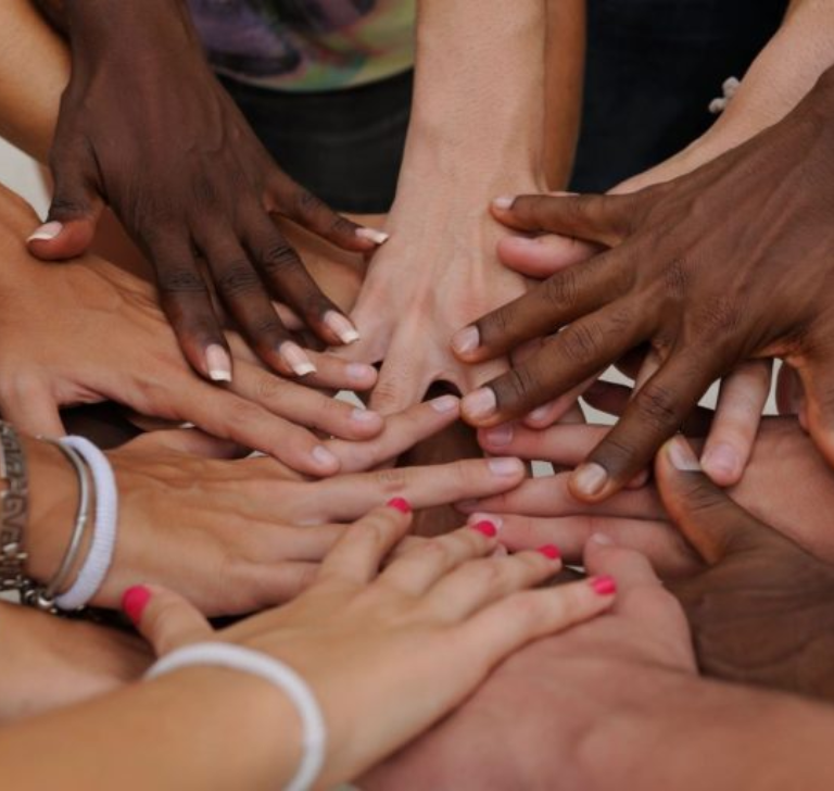 Diverse hands united in a circle.