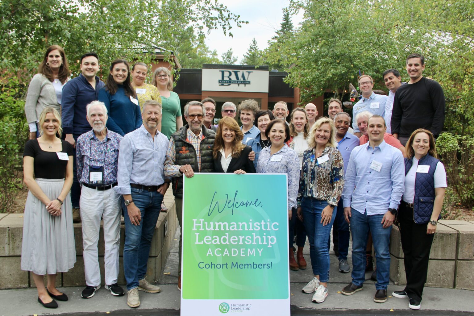 Group photo of diverse adults at a Humanistic Leadership workshop outdoors.