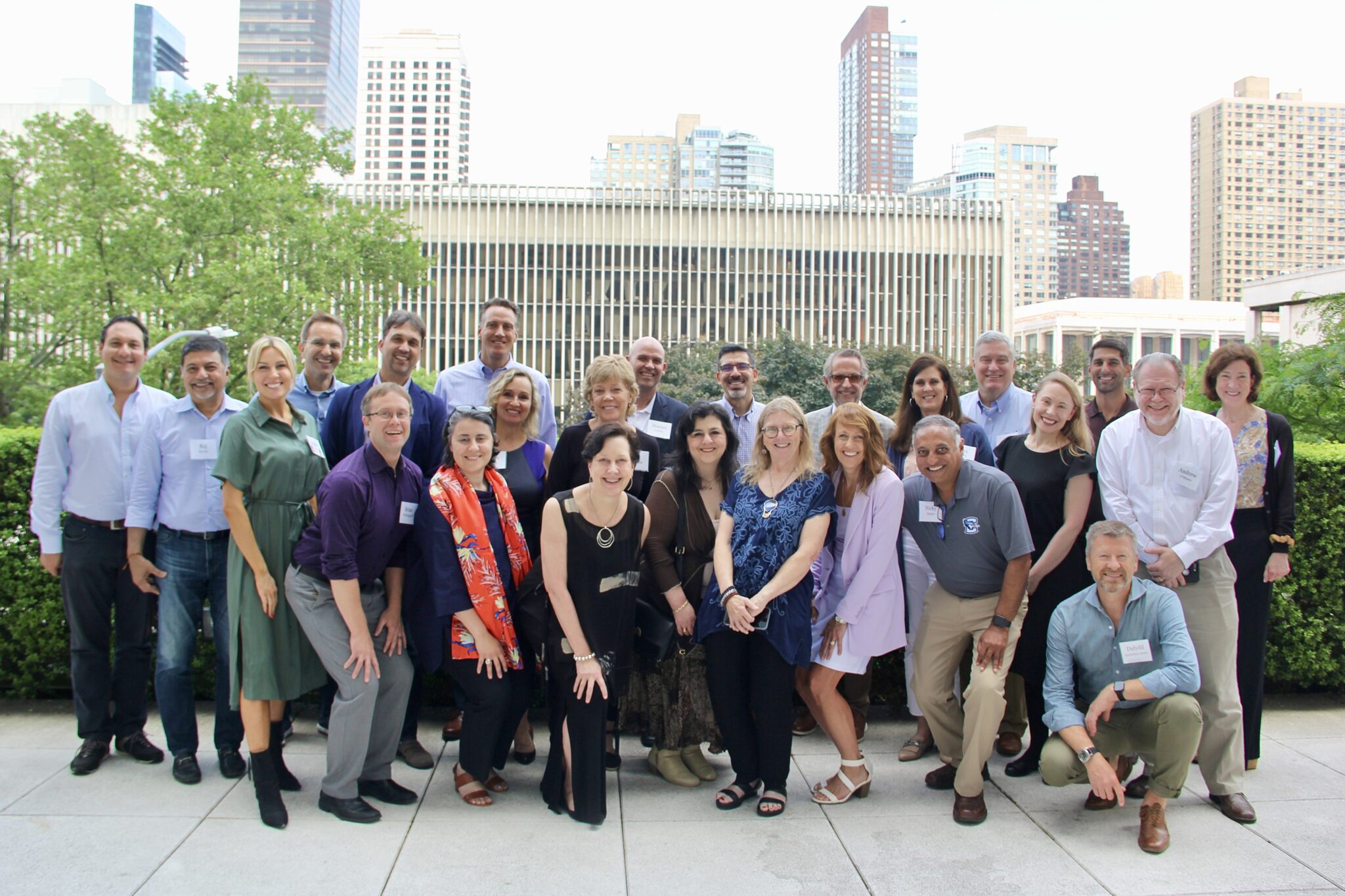 Group of diverse people posing outdoors in front of city buildings.