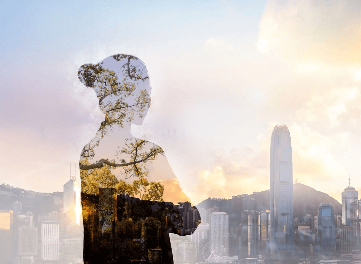 Silhouette of a person with cityscape blended into their figure at sunset.