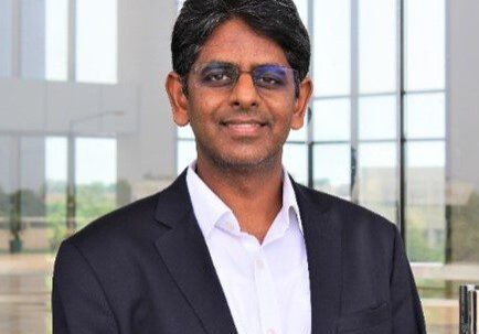Professional man in glasses and suit posing indoors.