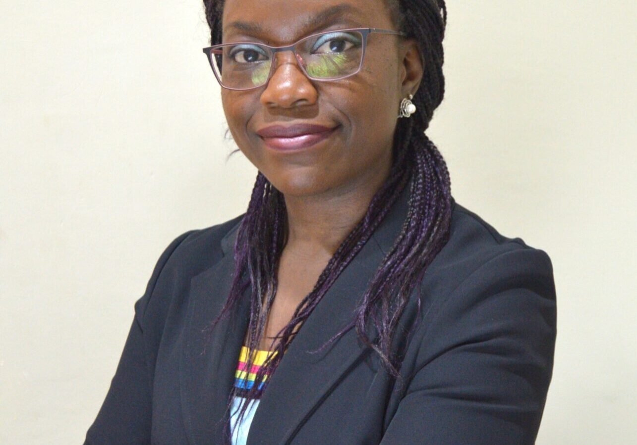 Confident woman in business attire, smiling.