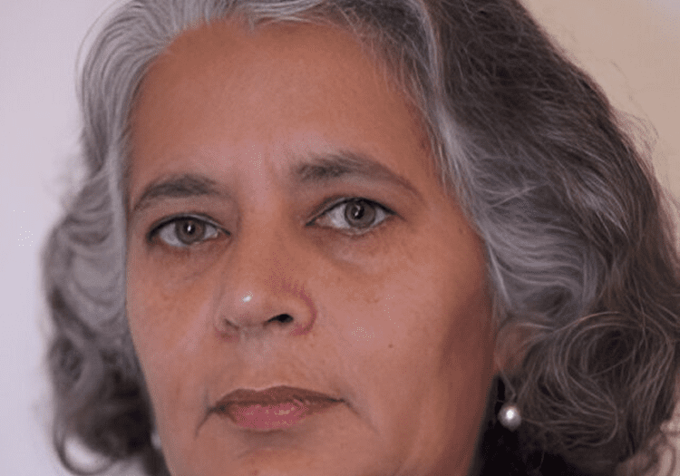 Woman with gray hair and serious expression.