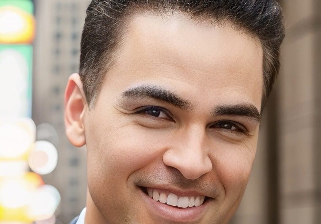 Smiling man in cityscape background.