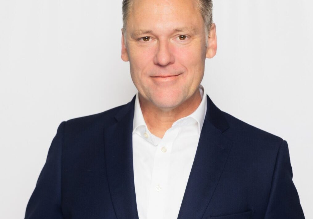 Professional man in a navy blazer and white shirt.