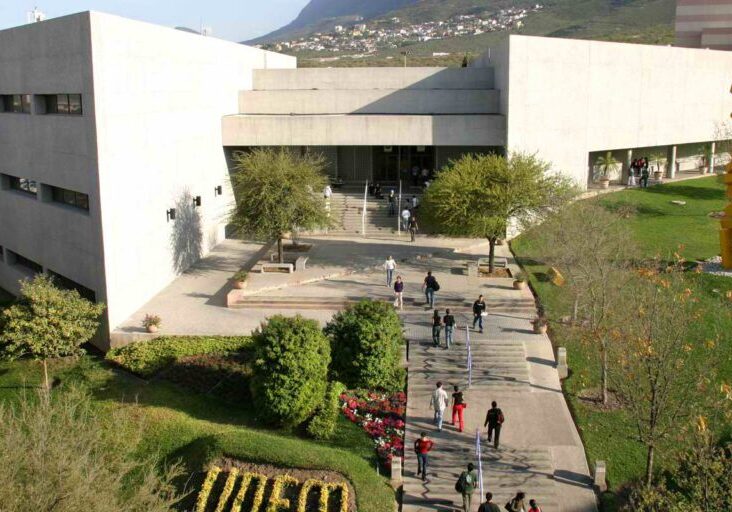 A university campus courtyard with students walking and sitting.