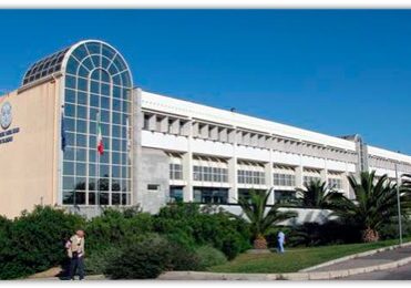 University building with palm trees outside.
