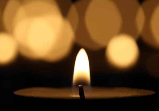 Candle flame with blurred lights background.