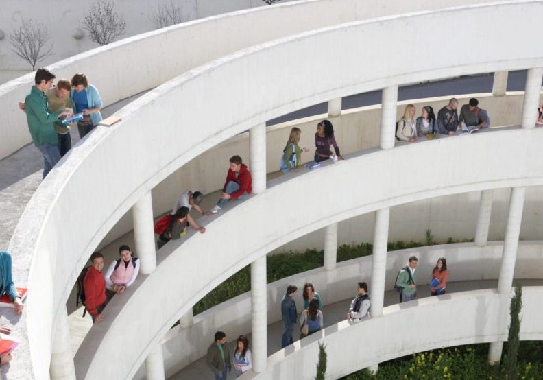 Students on circular balcony in open area.