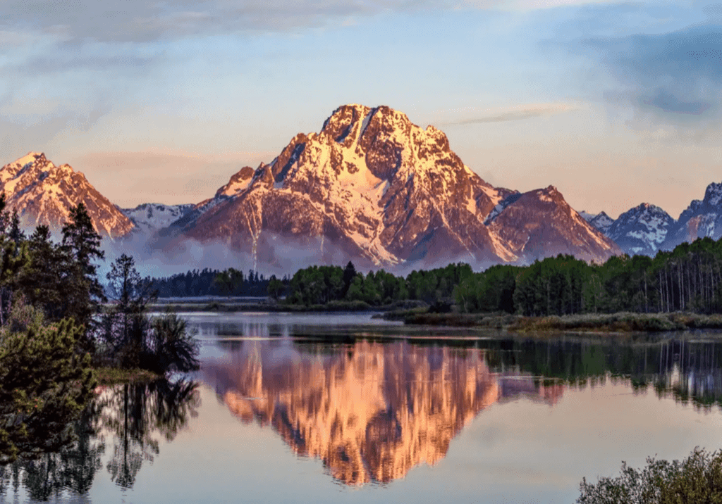 Mountain peaks reflecting in a calm lake at sunset.