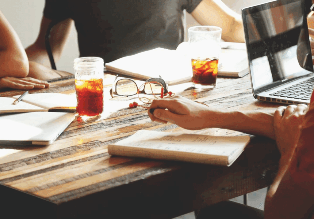 People working at a wooden table.