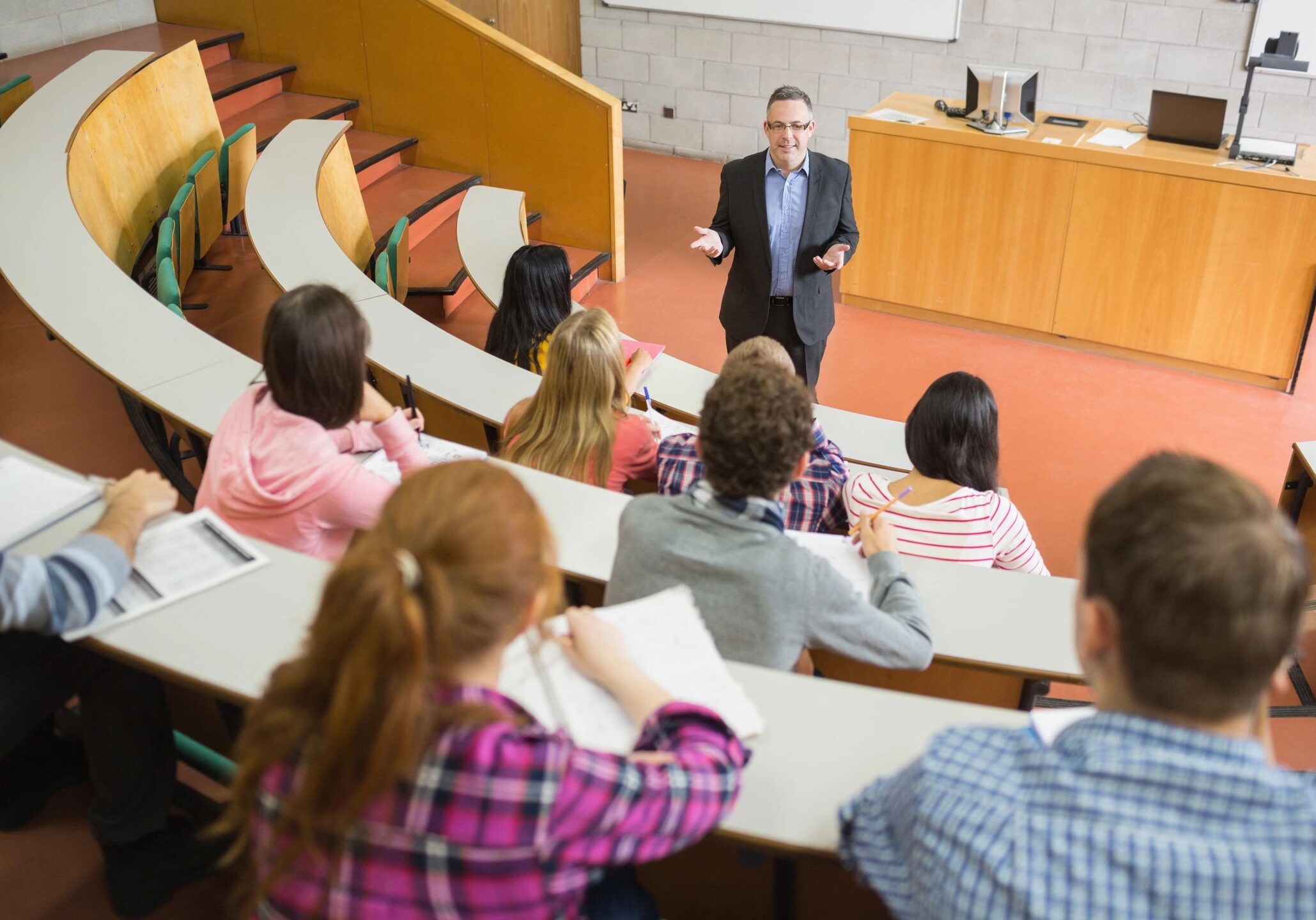 Lecture hall with professor and students seated.