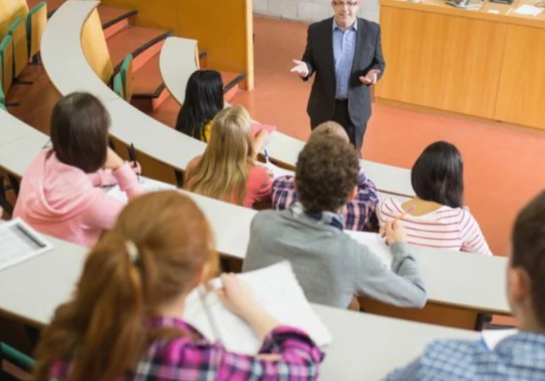 Professor lecturing students in a university classroom.