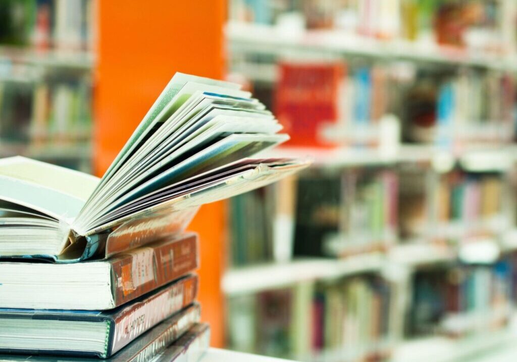 Open book on stacked books in library.
