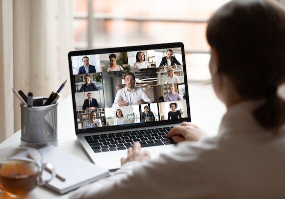 Person attending a virtual meeting on a laptop with multiple participants.